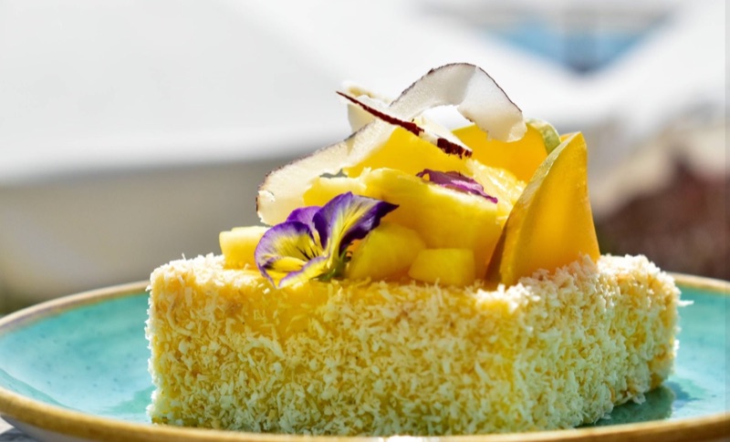 Coconut and mango cake with edible flowers